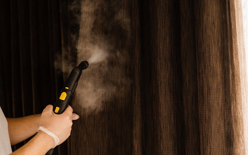 Using a steam cleaner on dark drapes without shrinking.