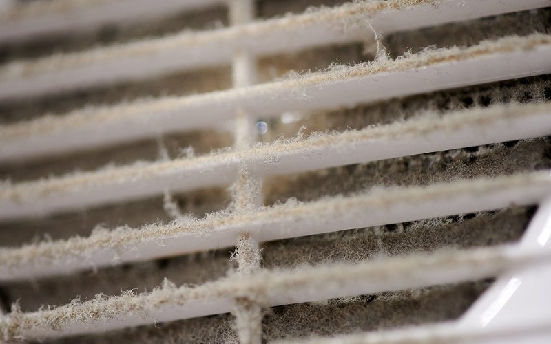 Close-up of air vent grilles covered in heavy dust.