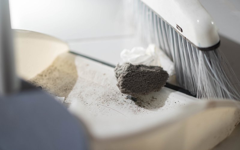 Thick construction dust and debris swept into a dustpan.