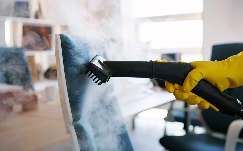 Professional steam cleaning a chair to eliminate bacteria and dirt